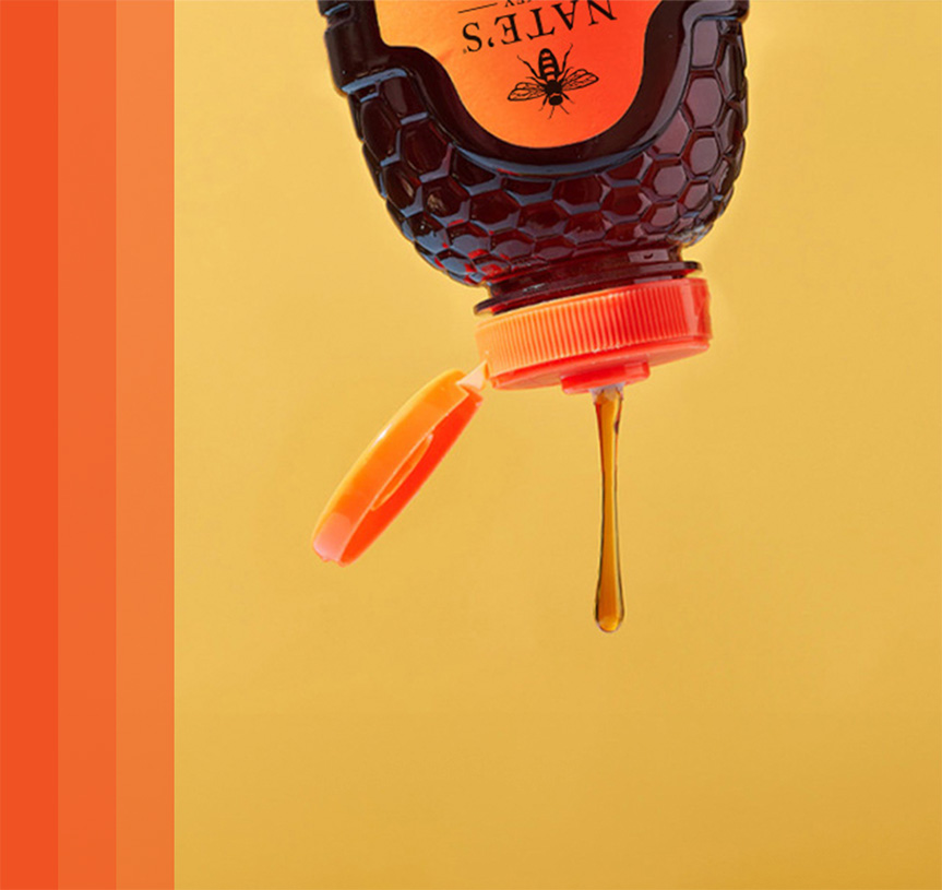 Honey dripping from bottle with yellow background and orange bars on left.
