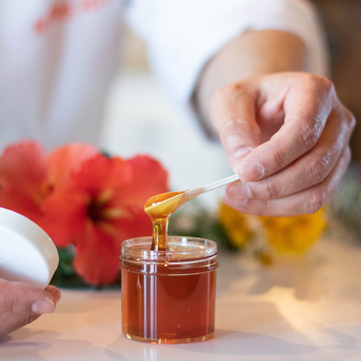 Lab tech testing honey in jar.